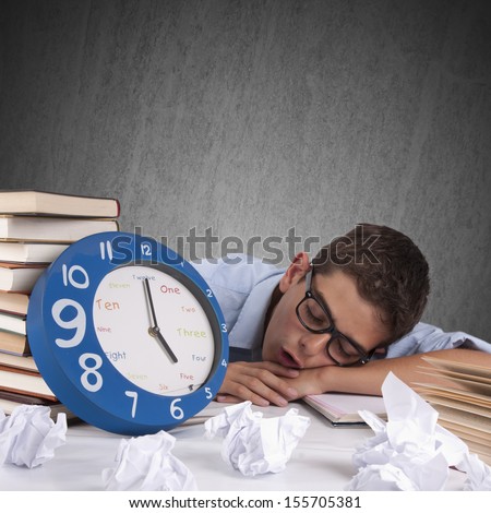 young man sleeping on the desk with books