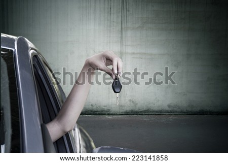 hand with car keys out the window