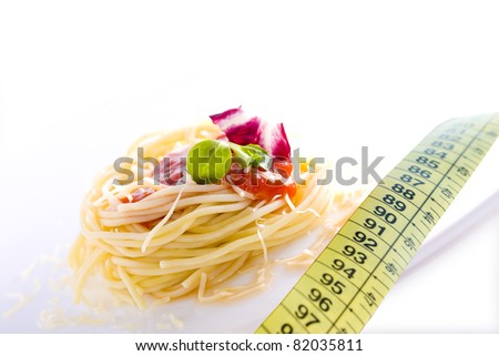 pasta dish and tape measure, a concept of balanced diet and healthy