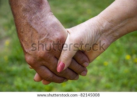 clasped hands of adults, seniors, golden age