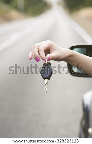 hand with car key in the foreground