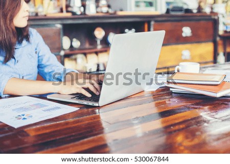 Young business woman working on laptop computer while sitting in vintage cafe bar.