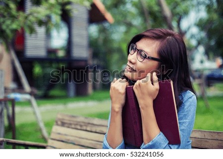 Hipster charming girl relaxing in the park while read book, Enjoy nature around.