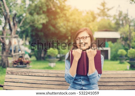 Hipster charming girl relaxing in the park while read book, Enjoy nature around.