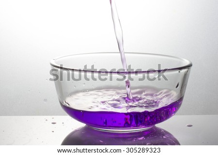pouring purple drink splash into glass on white background