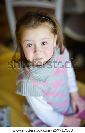 little girl with positive emotions sits at the table