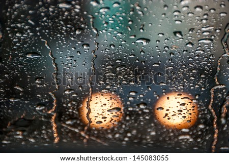 Rain drops on a window of car. Displays film grain.