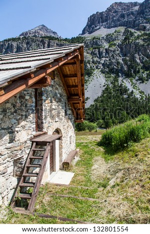 Swiss Alps, mountain cottage made of stone and wood, summer season