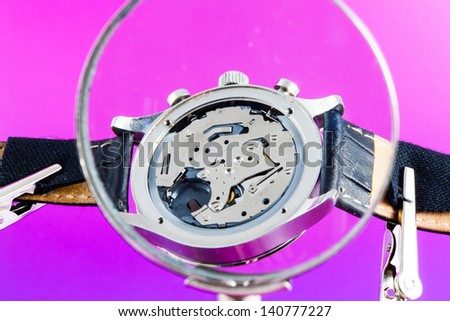 Elegant watch repaired using a magnifier with three handles
