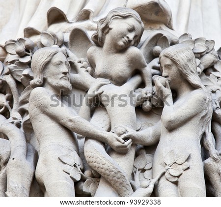 Detail on Notre Dame de Paris Cathedral fachade: Adame, Eve and the forbidden apple