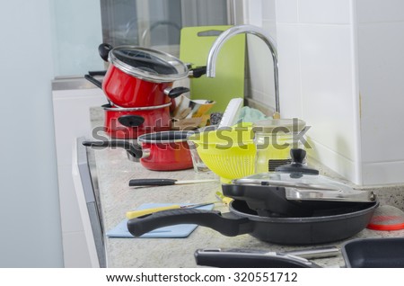 Dirty pan and pots in a messy kitchen in domestic household.