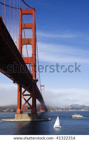 Golden Gate Bridge from below, featuring yachts and the typical fog rolling in.