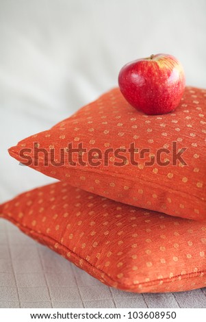 apple lying on pillows on the bed