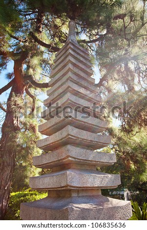 stone pagoda on the background of green trees
