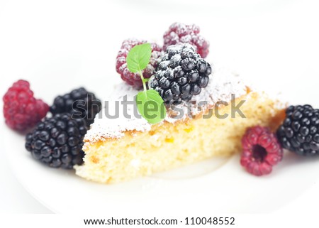 cake, raspberry, blackberry,nuts and mint on a plate on a white background