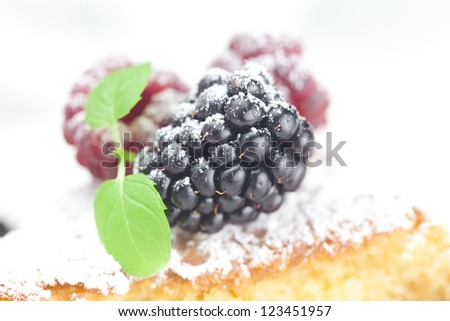cup, cake, raspberry, blackberry,nuts and mint on a plate on a white background