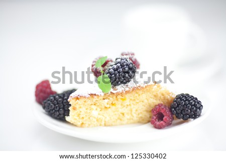 cup, cake, raspberry, blackberry,nuts and mint on a plate on a white background