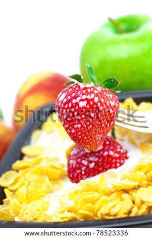 strawberry, peach, apple, kiwi, fork, milk and flakes in a bowl isolated on white