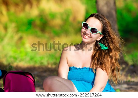 Portrait of young beautiful woman on picnic at summer green park in retro glasses