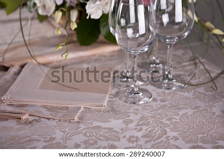 Luxury beige serviettes on the beige pattern table-cloth with flowers