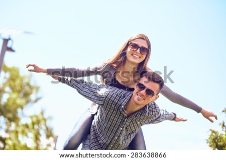 Holidays, vacation, love and friendship concept - smiling couple having fun in city