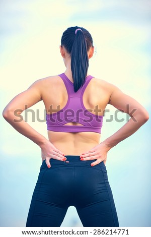 Fitness, healthcare and medicine concept - close up of sporty woman touching her back