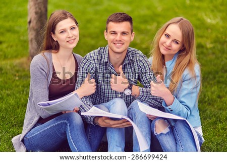 Group of college students exchanging notes outdoors