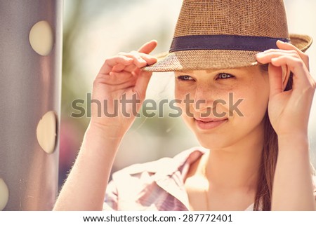 Closeup of thinking young woman outdoors in summer dress, city urban view