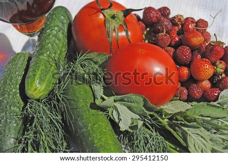 Still life with glass of wine. Cucumber, dill, mint, tomato, strawberry on a white tablecloth