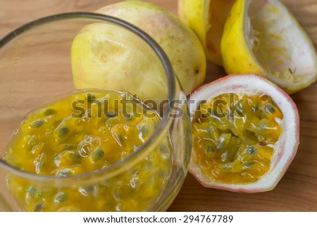 Fresh passion fruit juice with passion fruits on wooden background