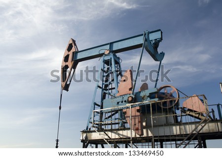 Oil and gas industry. Work of oil pump jack on a oil field. Blue sky