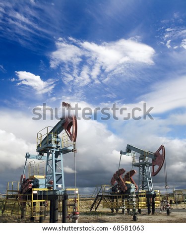 White clouds above oil pumps. Industrial scene