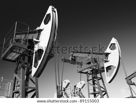 Oil and gas industry. Work of oil pump jack on a oil field. Wide Angle. Black and white photo