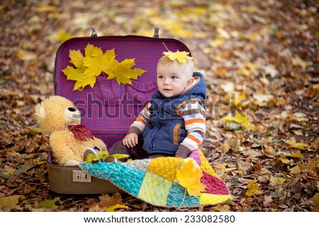 small boy sits in a suitcase