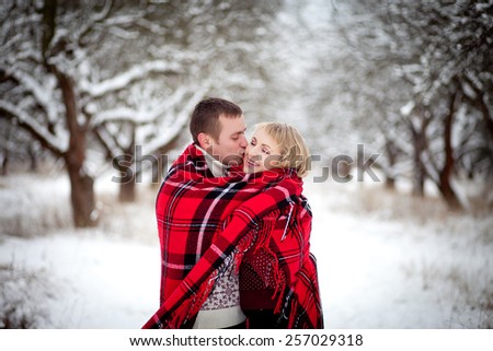 man and woman is heated under a blanket in winter