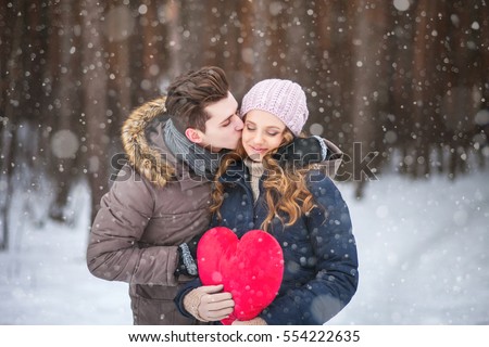 couple in the forest in winter, walk, kiss, hug and hold hands heart
