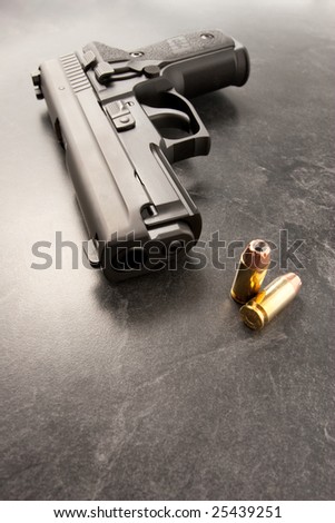 Wide angle of handgun with muzzle and two hollow point bullets.
