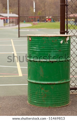 Trash receptacle at a public school playground and basketball court
