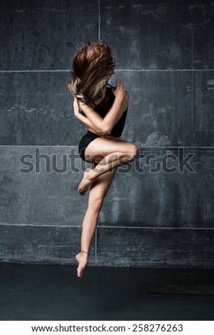 Female dancer jumping in contemporary dance in the studio