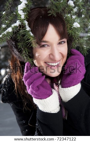 Cute woman under tree branches on snowy day
