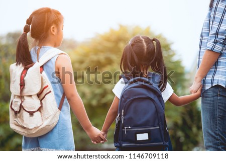 Back to school. Asian mother and daughter pupil girl with backpack holding hand and going to school together in vintage color tone