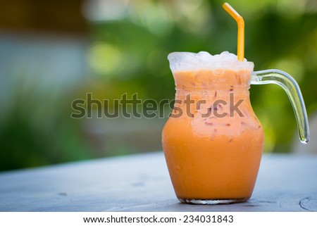 Iced Milk Tea with straw in jar on a wooden table