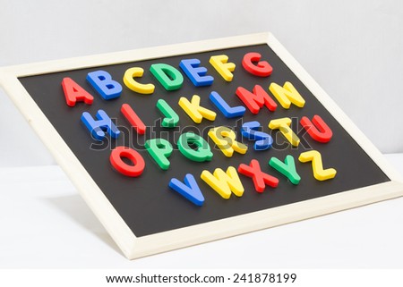 Magnet plastic alphabet on blackboard