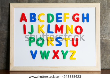 Magnet plastic alphabet on whiteboard on cement wall background