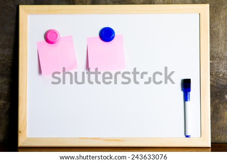 Whiteboard with marker and memo note on cement wall background
