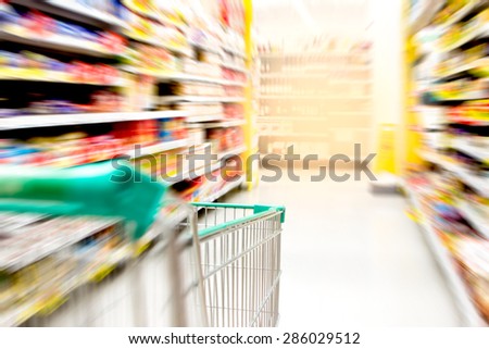 blurred image of shopping in supermarket with shopping cart