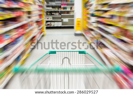 blurred image of shopping in supermarket with shopping cart