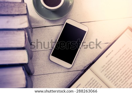 smart phone,cellphone and book with cup of coffee in vintage color filter