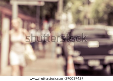 blur image of people walking on sidewalk beside road,vintage filter
