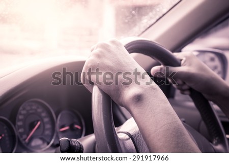 hands on steering wheel of car driving in vintage color tone